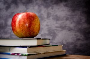 Our book recommendations — an apple rests on three books.